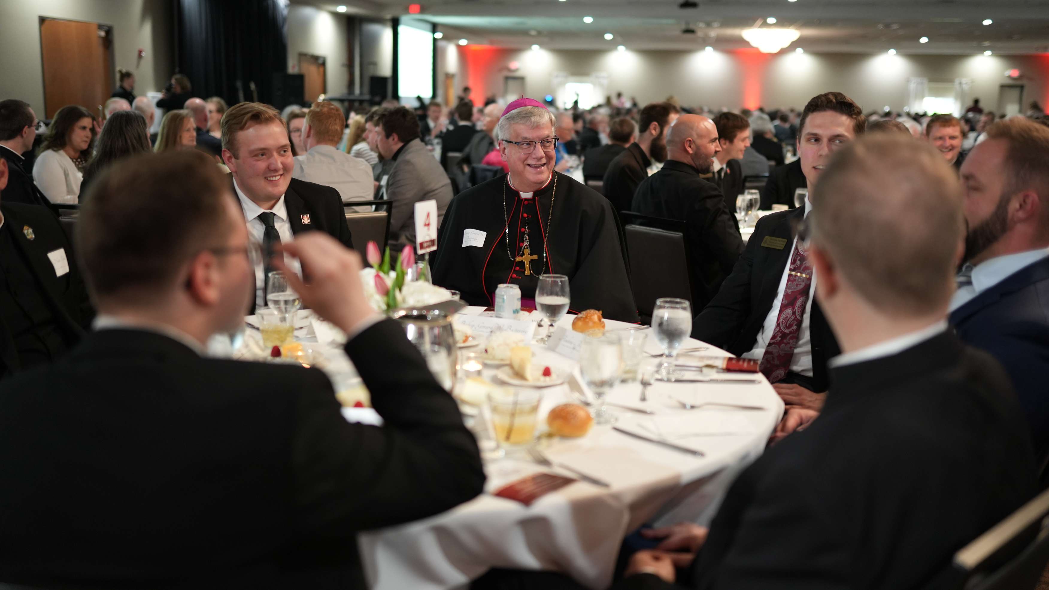 Bishops and seminarians chatting at 2025 annual Bishops and Rectors Dinner